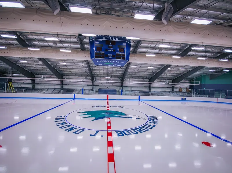 Resurfacer finishing a community arena sheet with a painted center ice logo